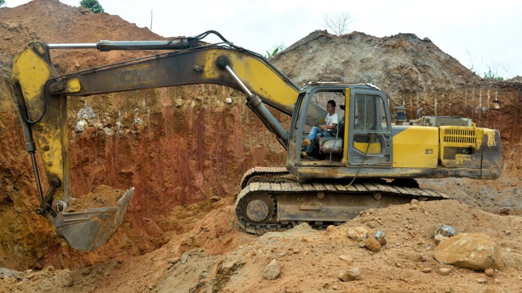 Un employé chinois d'une société minière conduit un bulldozer sur un site aurifère à Betare Oya, Cameroun, en 2018.