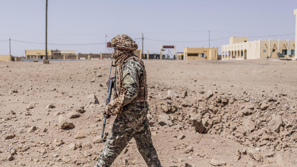 Un militaire inspecte un cratère de bombardement aérien dans la région de Kidal, au Mali
